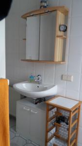 ein Badezimmer mit einem weißen Waschbecken und einem Schrank in der Unterkunft Ferienwohnung Bleeken in Schneverdingen