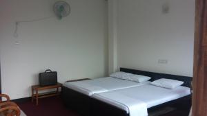 une chambre avec deux lits et une télévision dans l'établissement Southern Heritage Holiday Resort, à Deniyaya