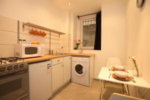 a small kitchen with a washing machine and a table at Kahwa Central Apartments in Budapest