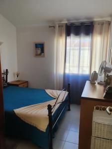 Un dormitorio con una cama azul y una ventana en Casa Bento by Umbral, en Albufeira