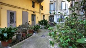 einen Innenhof mit Topfpflanzen vor einem Gebäude in der Unterkunft Italianway - Piazza Amendola 14 in Como