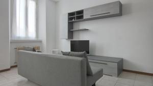 ein Wohnzimmer mit einem Sofa und einem TV in der Unterkunft Italianway - Piazza Amendola 14 in Como