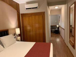 Habitación de hotel con cama y sala de estar. en Bourbon Londrina Business Hotel, en Londrina