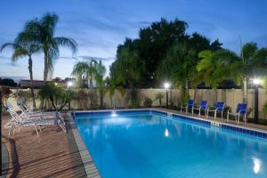 una piscina con sillas y una valla en Super 8 by Wyndham Bradenton Sarasota Area en Bradenton