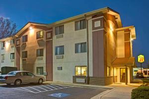 a building with a car parked in a parking lot at Super 8 by Wyndham College Park Wash DC Area in College Park