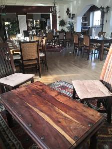Landhotel Saar-Mosel في Tünsdorf: طاولة وكراسي خشبية في مطعم
