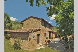 una grande casa in pietra con un sentiero di fronte di Tuscan Charme of Cottage Roccaio Countryside Cortona a Castiglion Fiorentino