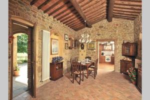 una cucina e una sala da pranzo con tavolo e sedie di Tuscan Charme of Cottage Roccaio Countryside Cortona a Castiglion Fiorentino