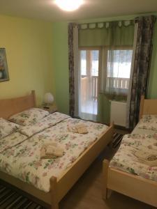 1 dormitorio con 2 camas y ventana en Ranch Marina en Koče