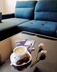 a coffee table with a cup of coffee and a plate of food at Hotel Vlaho in Skopje