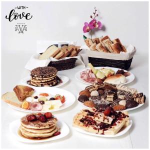 a table topped with plates of pastries and desserts at Hotel Vlaho in Skopje