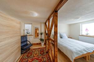 1 dormitorio con 1 cama, 1 silla y TV en Appartamenti Quattro Ducati, en Göppingen