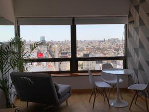 sala de estar con mesa, sillas y ventana grande en BUENOS AIRES BEST SKYSCRAPER en Buenos Aires