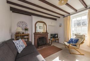 a living room with a couch and a fireplace at Jurassic Cottage in Portesham