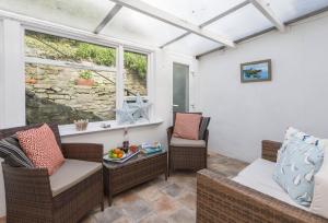 a screened in porch with two chairs and a table at Jurassic Cottage in Portesham