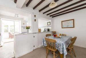 a kitchen and dining room with a table and chairs at Jurassic Cottage in Portesham +11 photos