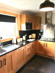 a kitchen with wooden cabinets and a sink at 10 Berisay Place in Stornoway