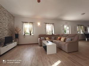 a living room with a couch and a tv at Villa Leen Dubrovnik in Ðurinići