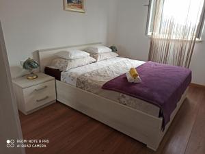 a bedroom with a bed with a purple blanket at Villa Leen Dubrovnik in Ðurinići +18 photos