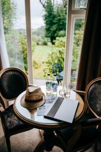 a table with a hat and glasses and a window at Flackley Ash Country House Hotel in Rye +71 photos