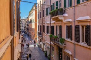 an alley in the city with people walking on the street at Condotti Palace in Rome