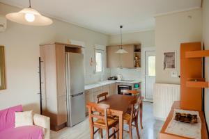 una cucina con tavolo e sedie e frigorifero di Seafront Apartment a Karfás