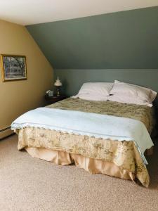 a large bed in a bedroom with a green wall at Maplecroft Bed & Breakfast in Barre