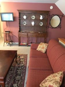 a living room with a couch and a mirror at Maplecroft Bed & Breakfast in Barre