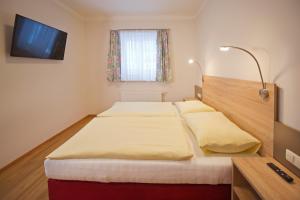Habitación de hotel con 2 camas y TV en Appartementhaus Riepler en Bad Gastein