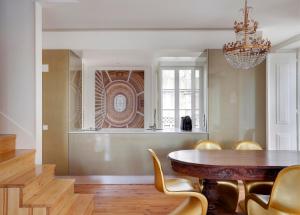 une salle à manger avec une table, des chaises et un lustre dans l'établissement Residentas Apostolos, à Lisbonne