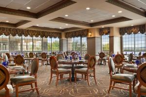 a dining room with tables and chairs and windows at Chateau on the Lake Resort Spa and Convention Center in Branson