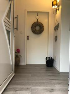 a hallway with a door and a wreath on the wall at Ferienwohnung Lands Huys in Dersum