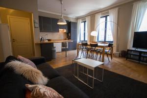uma sala de estar com um sofá, uma mesa e uma cozinha em Charming Apartments near Avenue Louise em Bruxelas