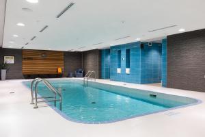 a large swimming pool in a building with blue tiles at Hotel Chateau Laurier Québec in Quebec City