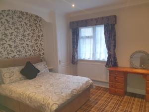 1 dormitorio con cama y ventana en Valley Grove Bungalows en Saundersfoot