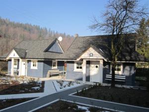 une petite maison blanche avec un arbre en face dans l'établissement Chatki Zielarki, à Wisła