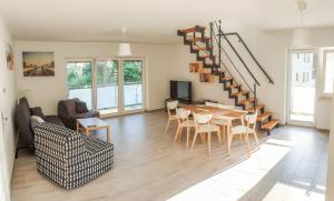 a living room with a table and chairs and a staircase at Apartamenty Ambra in Dębina