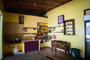 Hotel Marielos في تاماريندو: مطبخ بجدران صفراء وكاونتر في الغرفة