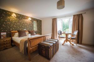 um quarto com uma cama, uma mesa e cadeiras em Flackley Ash Country House Hotel em Rye