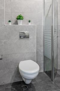 La salle de bains est pourvue de toilettes et d'une douche avec des plantes. dans l'établissement City center family relax apartment, à Netanya