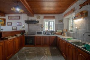een grote keuken met houten kasten en een spoelbak bij Traditional Village House in Méson Yerakaríon