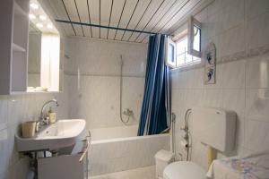 een badkamer met een wastafel, een bad en een toilet bij Traditional Village House in Méson Yerakaríon +29 foto's