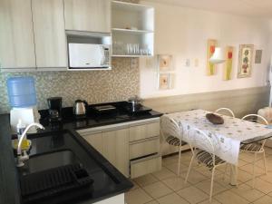 una cocina con fregadero y mesa. en Atlântico Flat ap 204 em Ponta Negra, en Natal