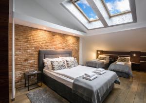 a bedroom with two beds and a brick wall at Yourplace Biskupia Old Town Apartments in Kraków