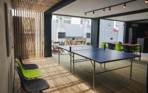 a conference room with a table and green chairs at Innbox - Canasvieiras 2 in Florianópolis