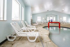 a pool with white lounge chairs and a swimming pool at Cobblestone Suites - Ripon in Ripon