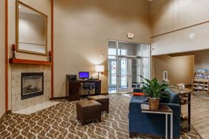 a living room with a blue couch and a fireplace at Cobblestone Suites - Ripon in Ripon