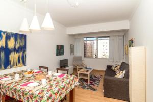 a living room with a table and a couch at White Apartment - T2 near Beach in São João do Estoril