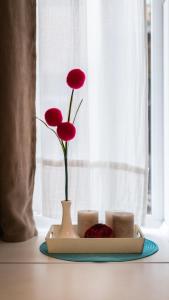 リヴィウにあるMini Apartments on Roppoporta 7a-2の赤い花とろうそくを添えた皿