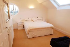 een witte slaapkamer met een bed en een raam bij Large 2 ensuite bedroom flat with lovely views in Leeds